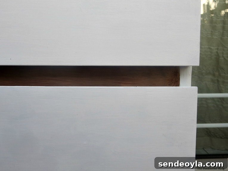 Close up of white drawers with walnut front frame of dresser.
