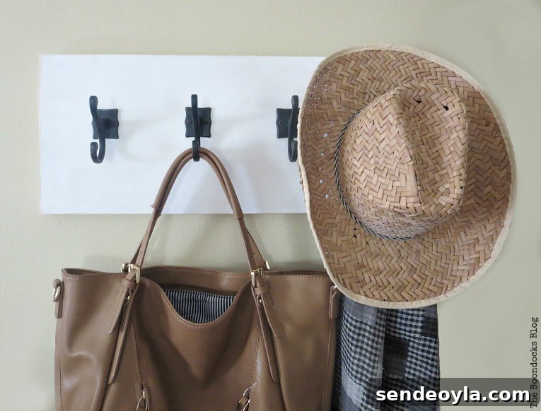 DIY Farmhouse Coat Rack for Your Entryway 12 bag, scarf and hat hanging from wood wall hanger, How to Make a Wooden Wall Hanger www.theboondocksblog.com