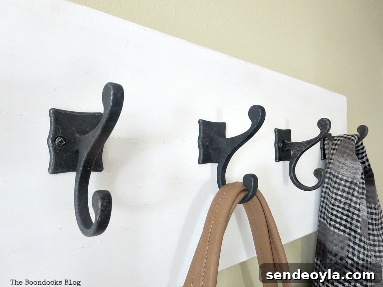 DIY Farmhouse Coat Rack for Your Entryway 13 4 metal hooks with a scarf and bag, How to Make a Wooden Wall Hanger www.theboondocksblog.com