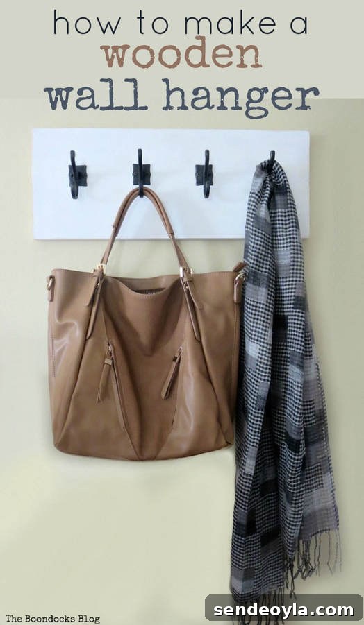 DIY Farmhouse Coat Rack for Your Entryway 17 A completed DIY coat rack hung on a beige wall. A brown leather purse adn grey checkered scarf hang off of the hooks.