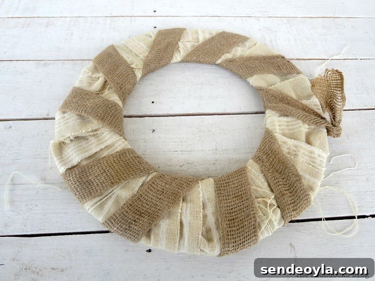 How to Turn a Dollar Store Vine into a Fall Wreath 6 donut shaped cardboard wrapped with white fabric strips and burlap ribbon