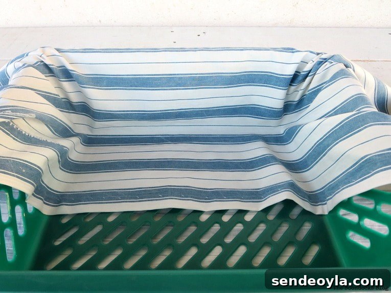 Upcycle Broken Plastic Baskets into Fabric Storage Bins 6 Folding the fabric over the plastic basket.