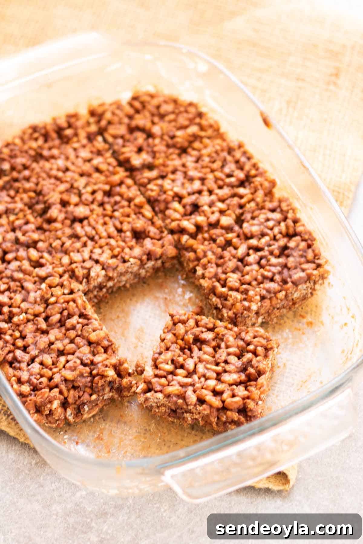 cutting rice krispie squares in a baking dish