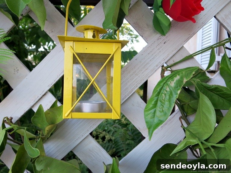 DIY Colorful Fence with Dollar Store Flowers 9 Yellow lantern on the lattice flower wall.