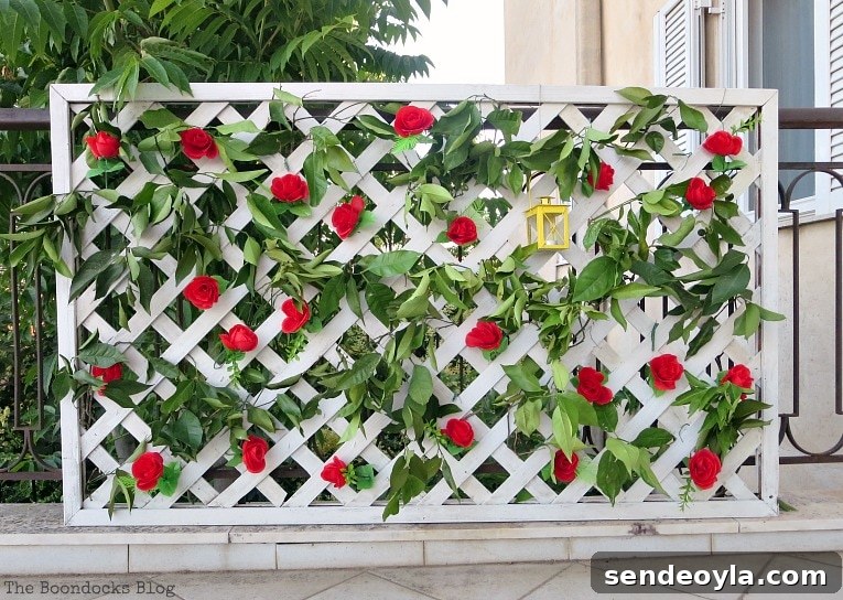 DIY Colorful Fence with Dollar Store Flowers 10 Finished lattice flower wall with red roses, greenery and yellow lantern.