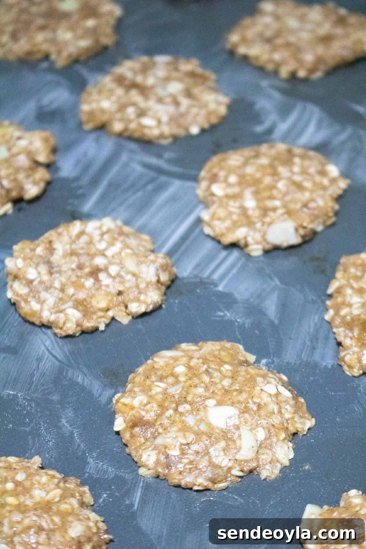 Classic Crunchy Anzac Biscuits Recipe 7 buttered bakig sheet with Anzac biscuits flattened