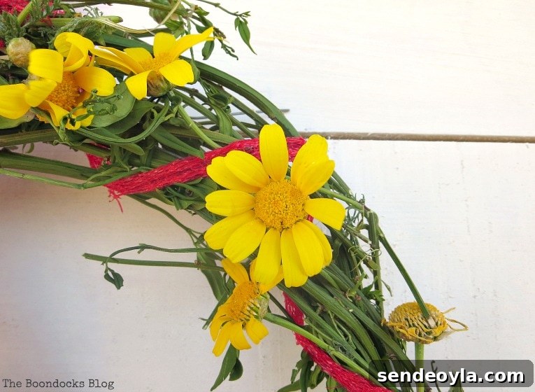 Adding yellow daisies to the wreath