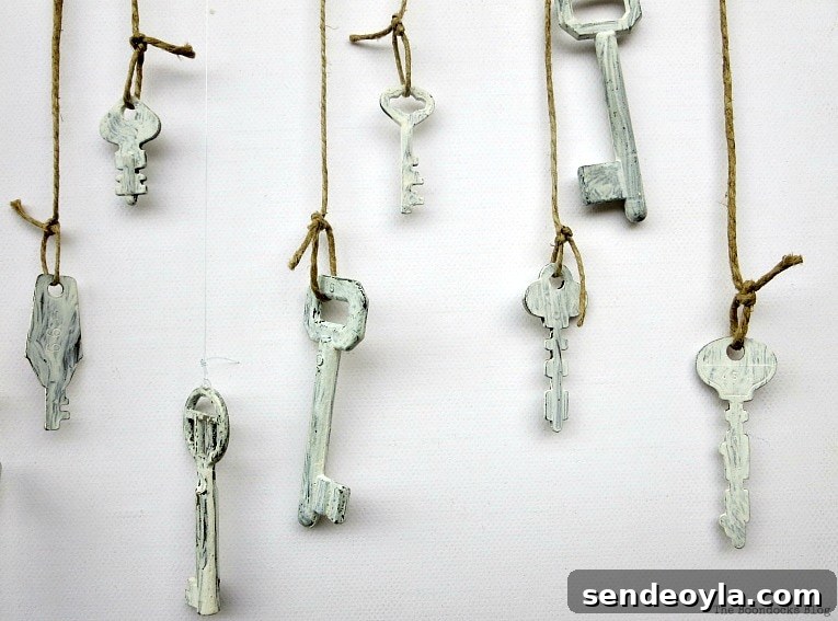 many pretty keys hanging over canvas, How to Make Simple Canvas Wall Art with Keys, www.theboondocksblog.com
