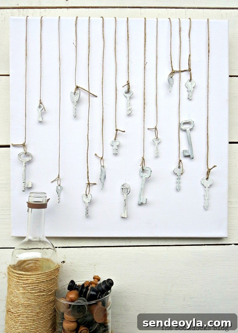 Canvas with chalky painted keys hanging from twine, How to Make Simple Canvas Wall Art with Keys, www.theboondocksblog.com