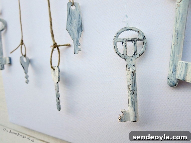 thin twine tied to keys, How to Make Simple Canvas Wall Art with Keys, www.theboondocksblog.com