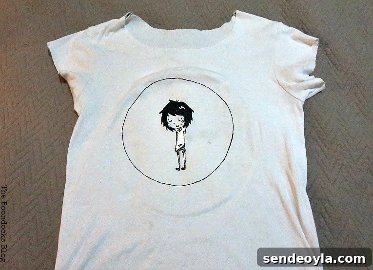 DIY T-Shirt Wall Art: Transform a Tee into Home Decor 3 Old white tshirt with a circle and an image of a girl character in the middle.