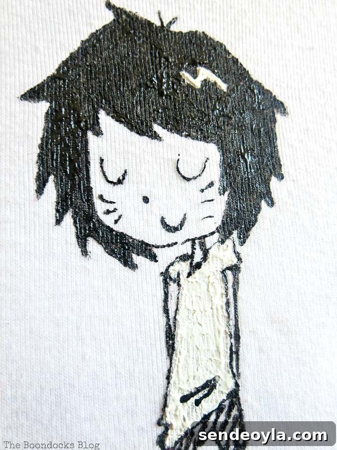 DIY T-Shirt Wall Art: Transform a Tee into Home Decor 9 Close up of the girl character drawing on a white tshirt.