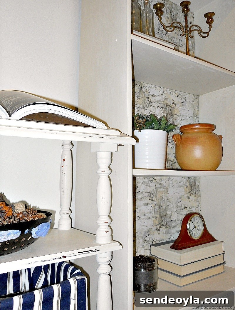 Transform Bookcases with Paint and Wrapping Paper 2 Distressed dictionary stand next to bookcase painted in white. Shelves are decorated with clay pot, flower pot, books, bottles and a clock.