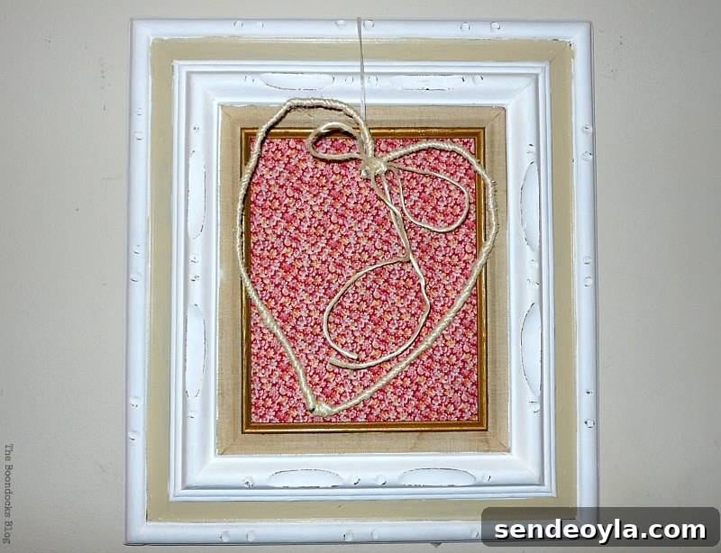 Heart dangling over frame with red fabric