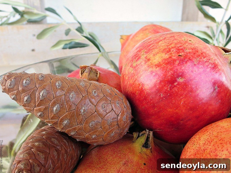 DIY Natural Thanksgiving Table Centerpiece Ideas 12 Close up of pine cones and pomegranates in a glass bowl.