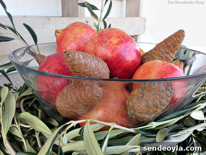 DIY Natural Thanksgiving Table Centerpiece Ideas 9 Pomegranetes and pinecones inside glass bowl placed with in olive branch circle.
