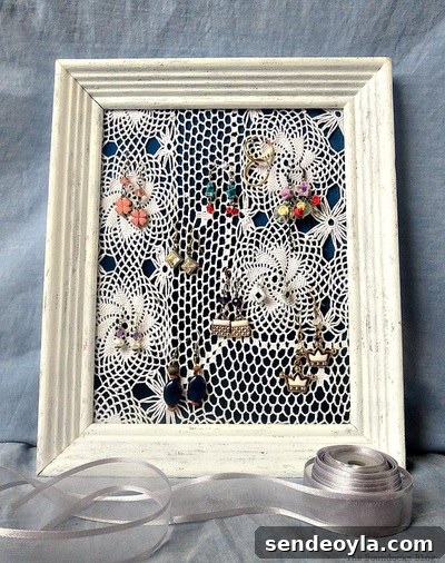 DIY Earring Organizer Ideas to Declutter Your Jewelry 2 Earring organizer made with a frame, a blue satin blouse and a doily.