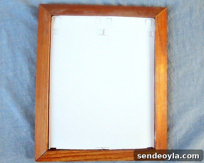 DIY Earring Organizer Ideas to Declutter Your Jewelry 4 Cutting a cardboard piece to fit the wood picture frame.