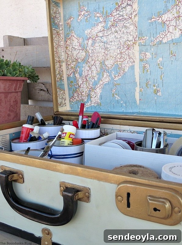 Suitcase full of supplies and decoupaged with maps, What's Inside the Vintage Suitcase? www.theboondocksblog.com