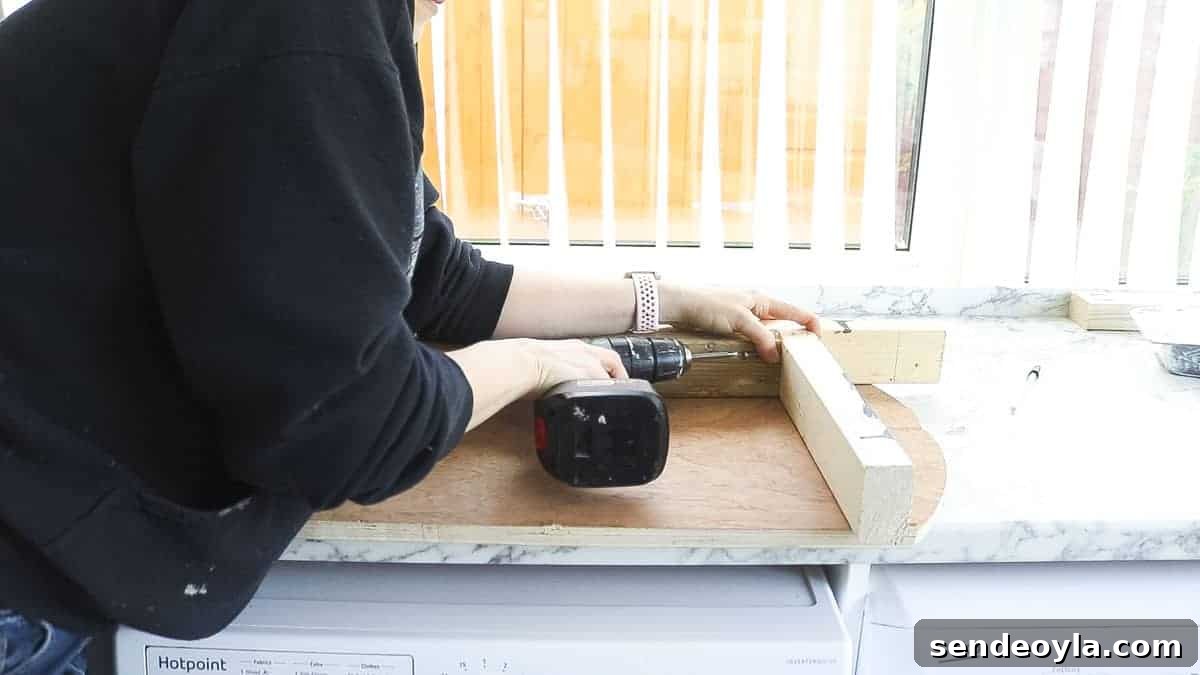 DIY TV Stand from Scrap Wood: Step-by-Step Guide 10 Screwing pocket holes into DIY TV stand wooden frame