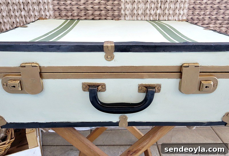 Transform a Vintage Suitcase into Chic Home Storage 15 Showing how the front of the suitcase has gold clasps that are not symmetrical to the handle.