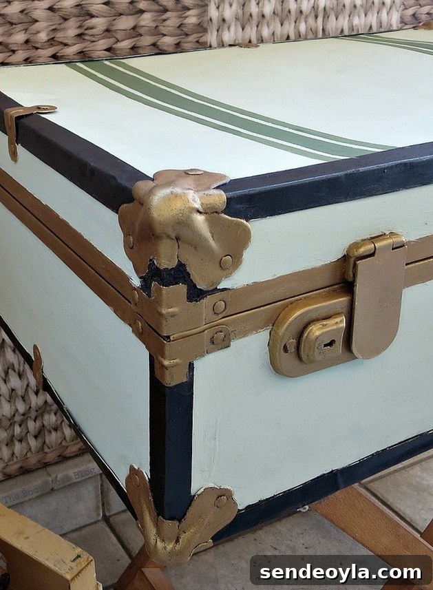 Transform a Vintage Suitcase into Chic Home Storage 19 A different angle showing a close up of green painted stripes, gold clasps and gold bumper on the vintage suitcase.