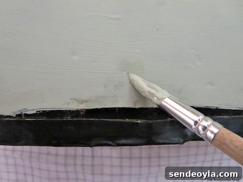 Transform a Vintage Suitcase into Chic Home Storage 10 Using a paintbrush to touch up a spot with paint.