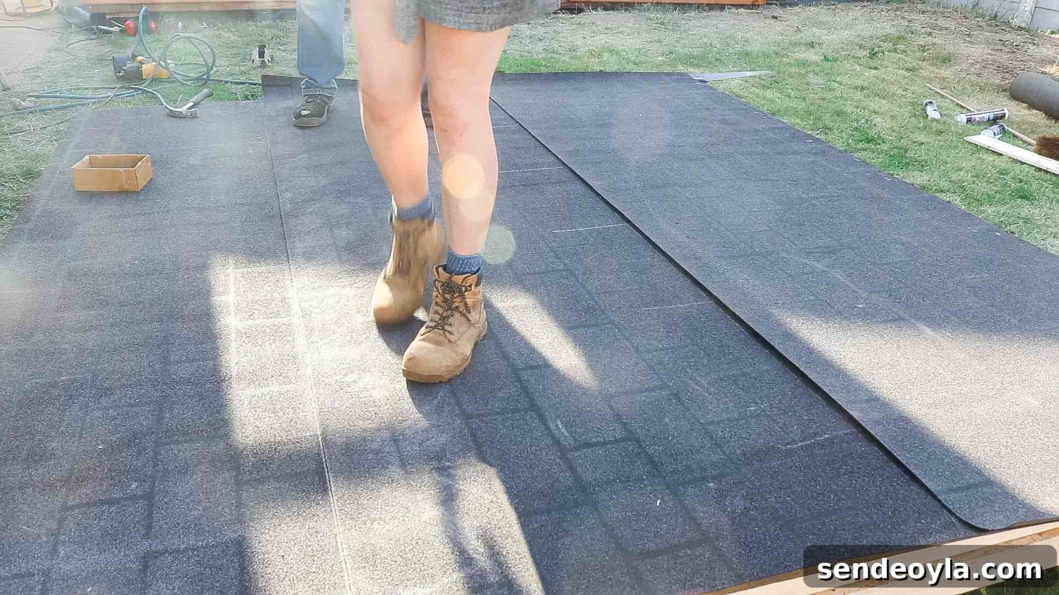 Install Roofing Felt on a Shed: Step-by-Step Tips 12 female woodworker pressing down felt and bitumen with her feets