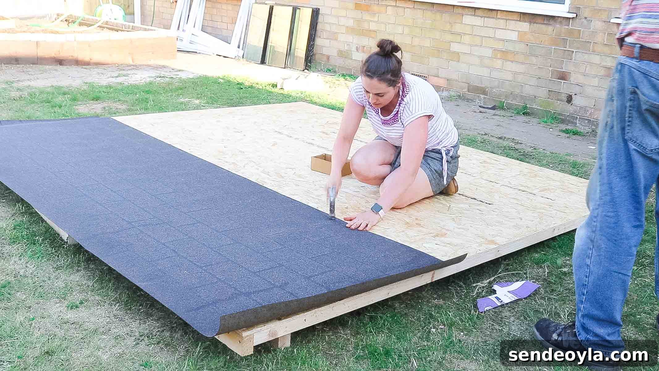 Install Roofing Felt on a Shed: Step-by-Step Tips 4 Vikkie Lee clout nailing shed felt on a roof framework with OSB