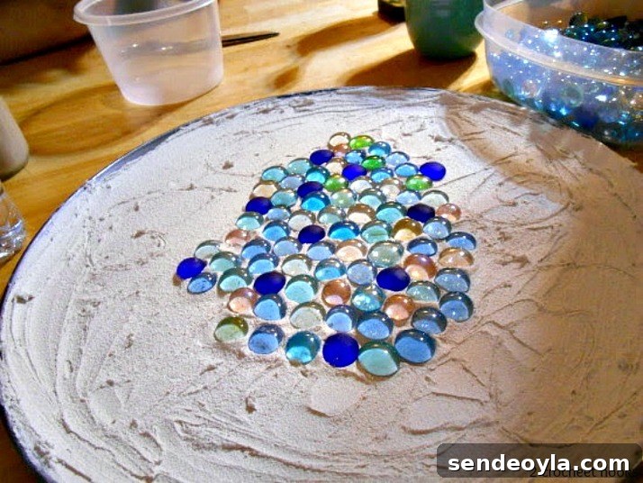 Adding marbles on the grout topped pizza pan.