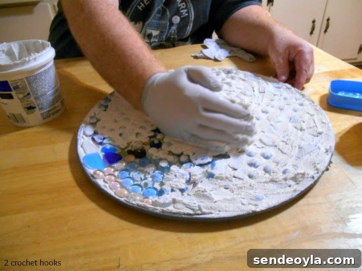 spreading grout on sea glass and marbles.