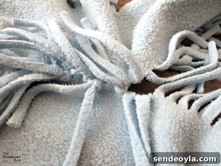 DIY Minimal-Sew Fleece Pillow 6 Tying fringe while watching TV